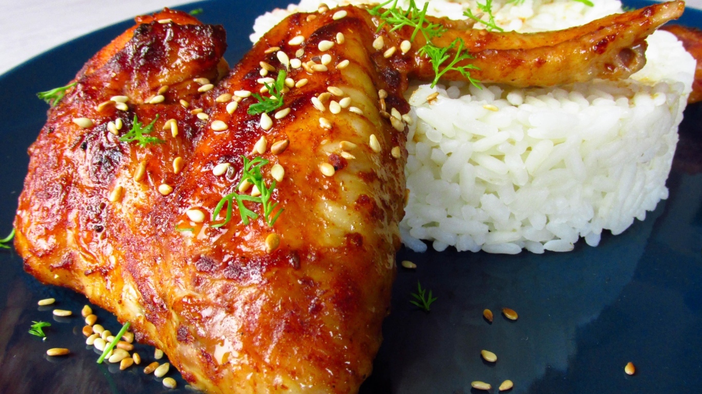 Рис на тарелке с жареным куриным крылом