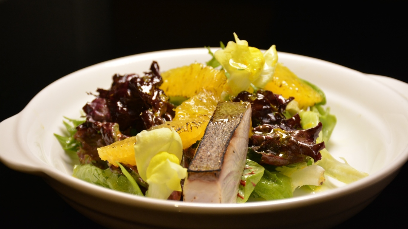 Кусочки рыбы с салатом и лимоном в тарелке