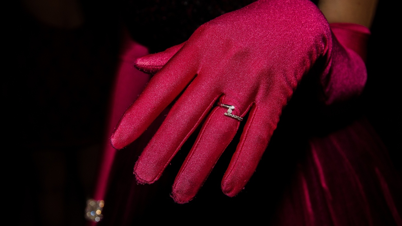 Женская рука с красной перчаткой и кольцом