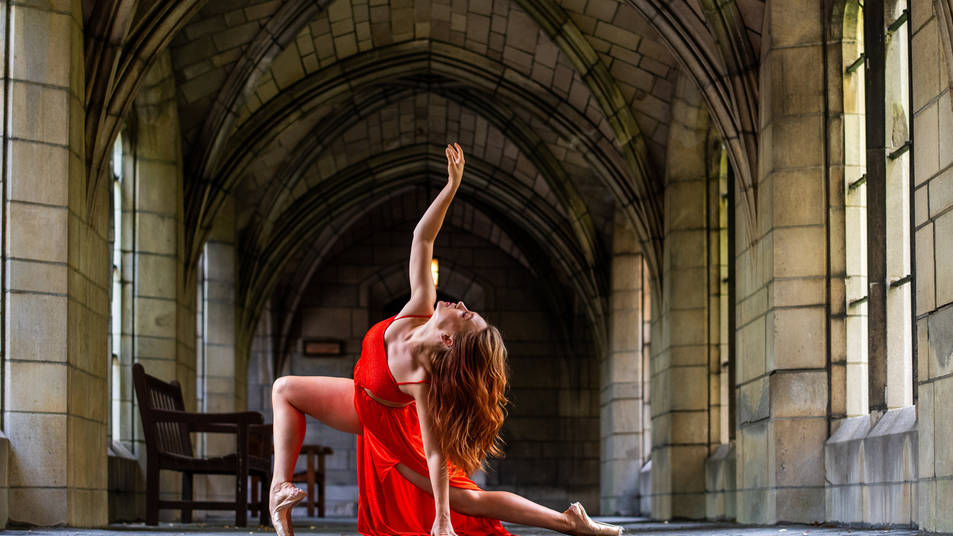 Девушка в красном наряде танцует в здании