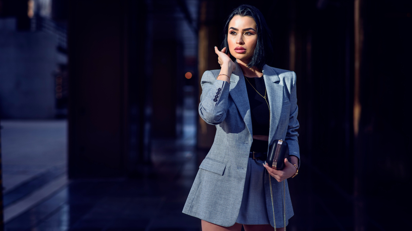 Деловая девушка в сером костюме с сумочкой