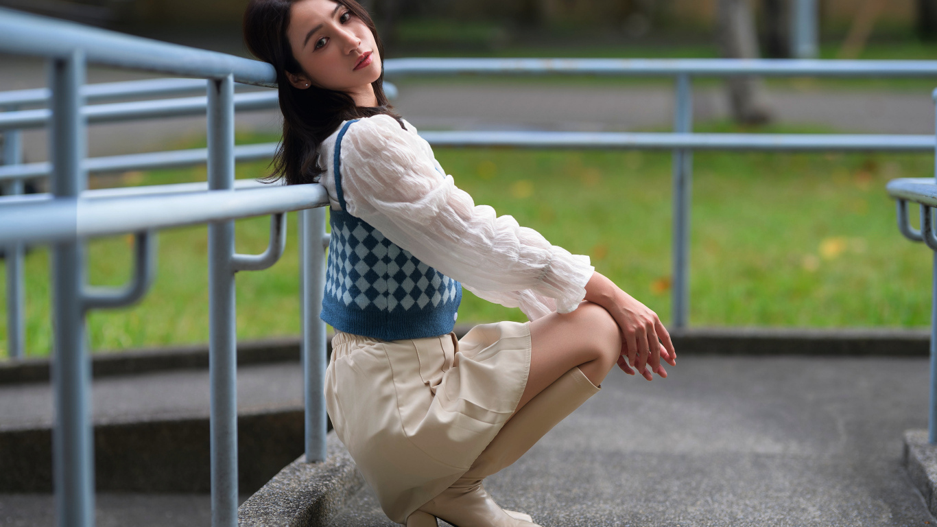 Милая девушка азиатка сидит у перил