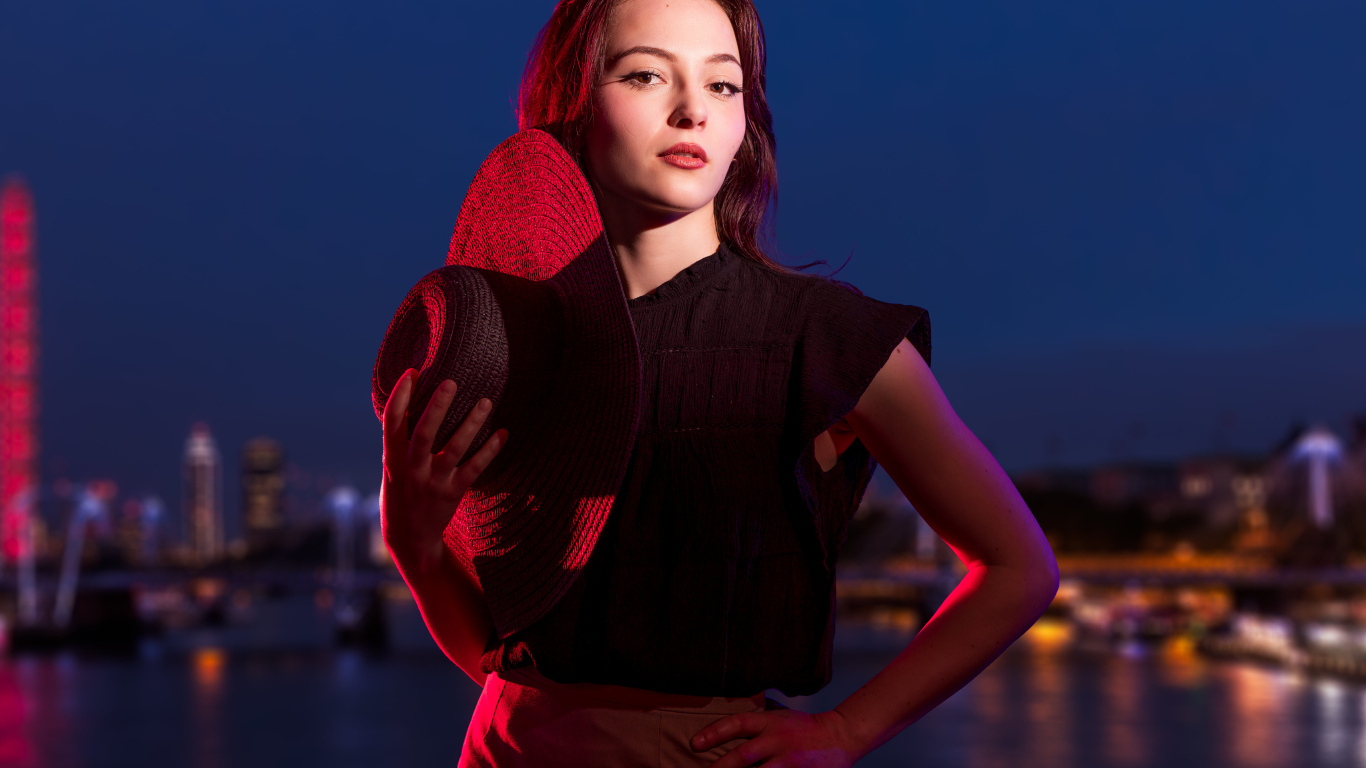 Девушка в лучах света со шляпой в руках