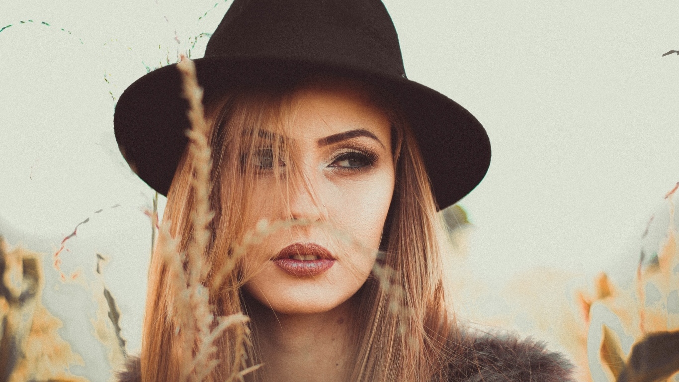 Серьезная девушка в черной шляпе 