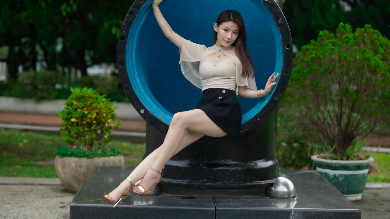 Стройная длинноногая азиатка сидит в трубе
