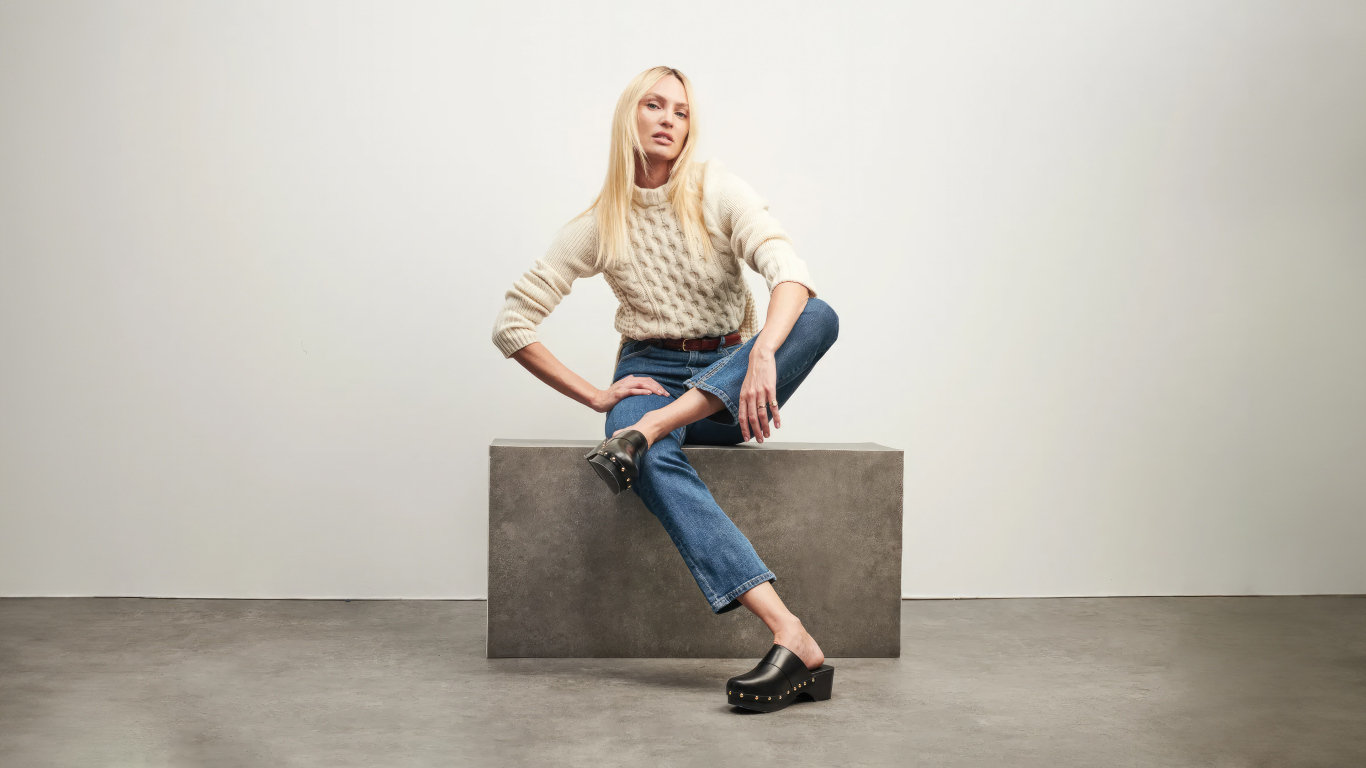 Модель Кэндис Свейнпол сидит на фоне серой стены