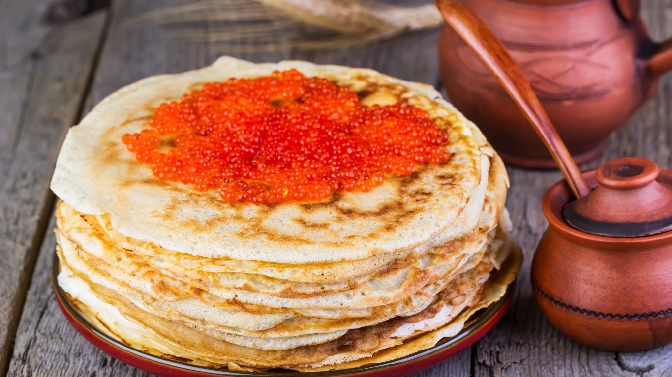 Аппетитные блины с красной икрой на столе на Масленицу
