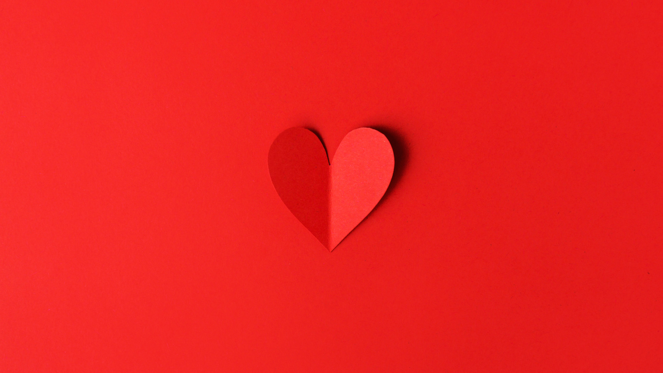 Маленькое бумажное сердце на красном фоне