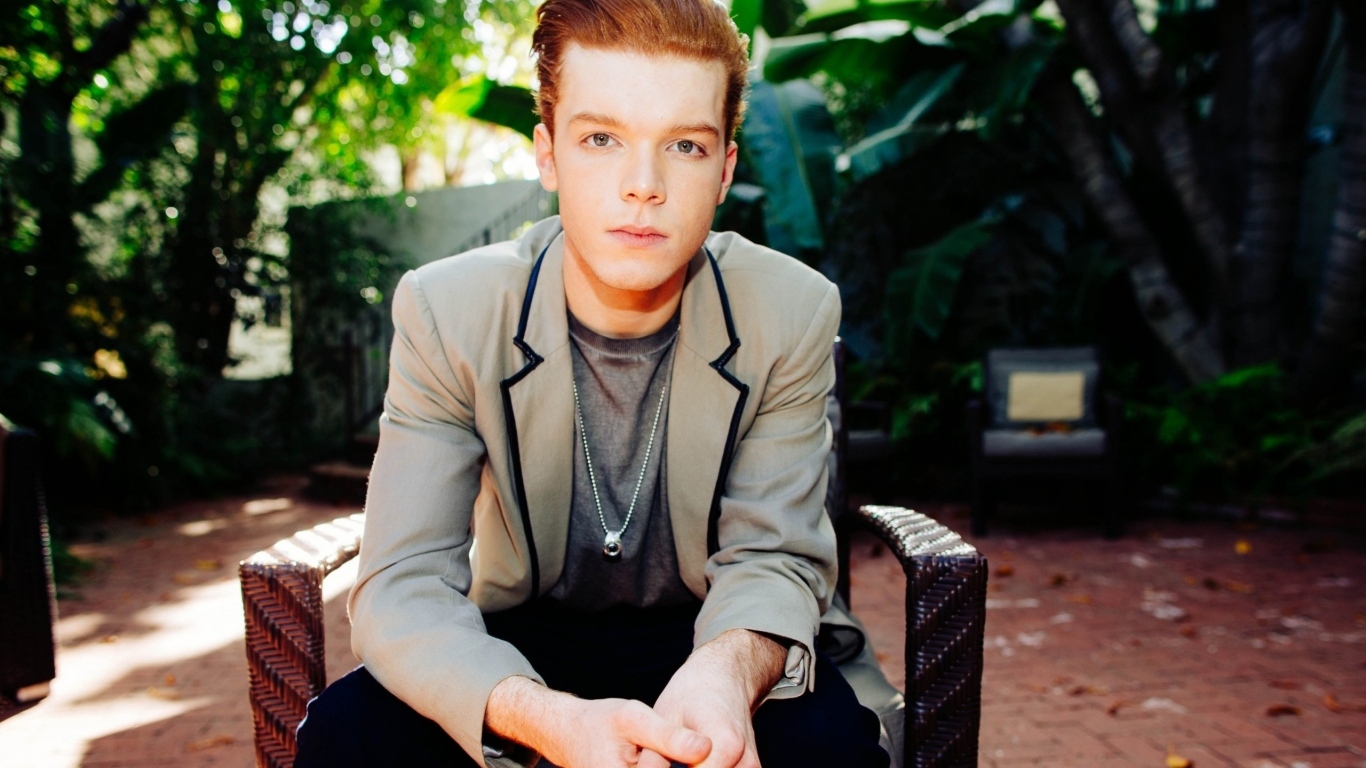 Актер Камерон Монахэн сидит в кресле