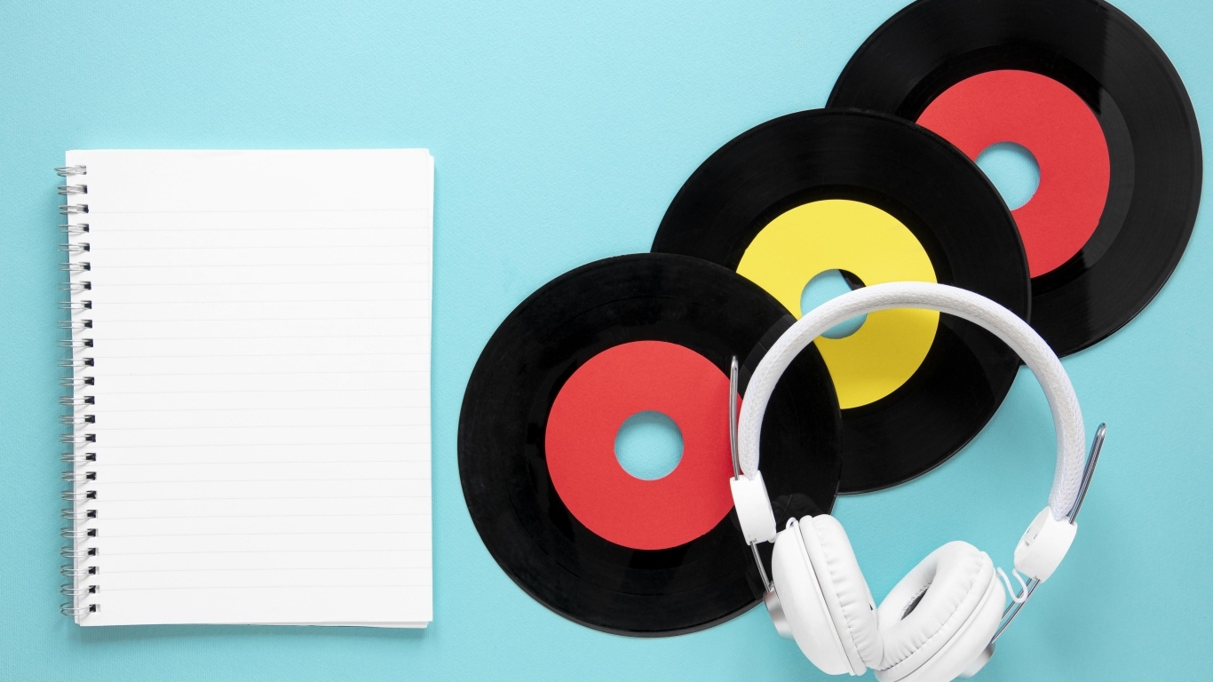 Пластинки на голубом фоне с блокнотом и наушниками