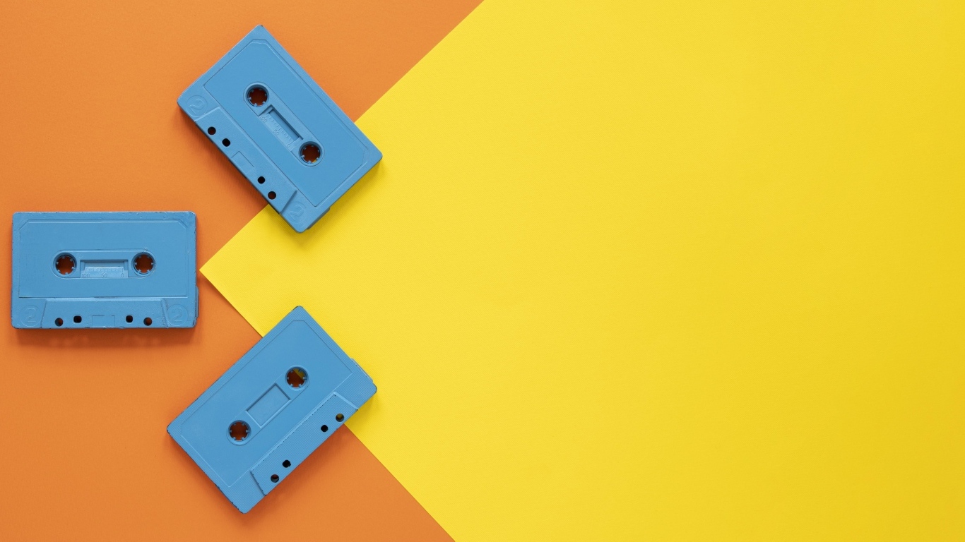 Три голубые кассеты на желто-оранжевом фоне