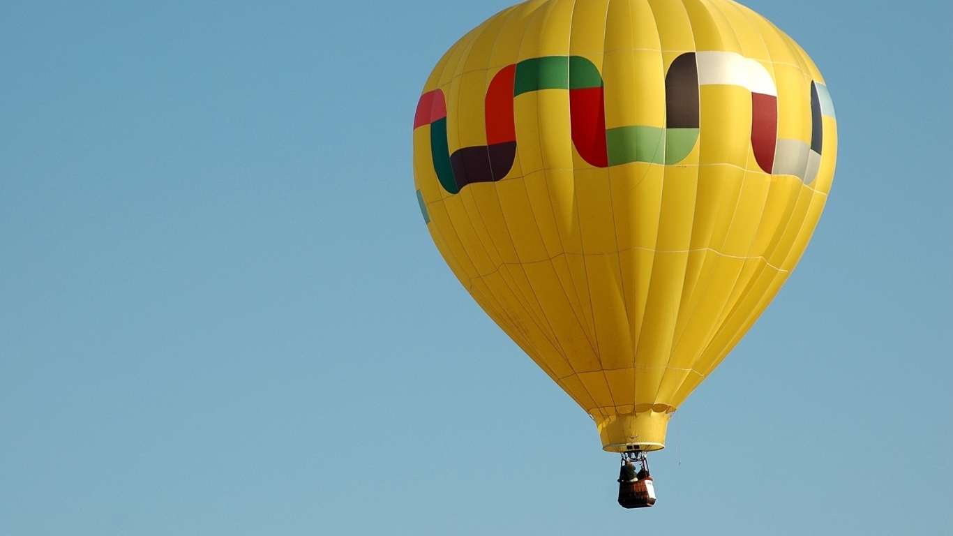 Большой желтый воздушный шар в голубом небе