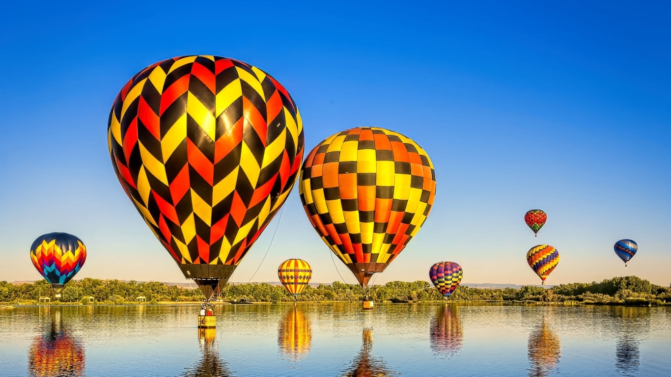 Большие воздушные шары над водой на фоне голубого неба