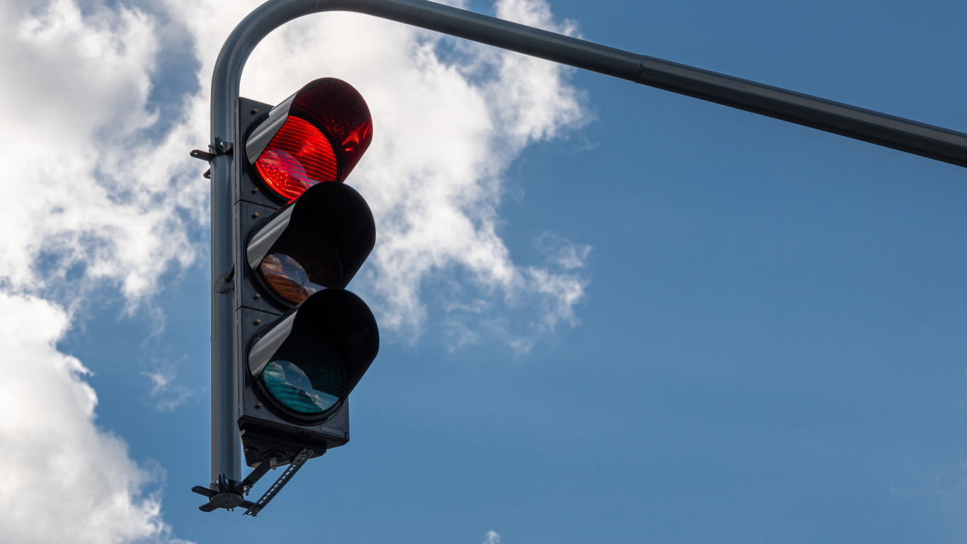 Красный свет светофора на фоне неба