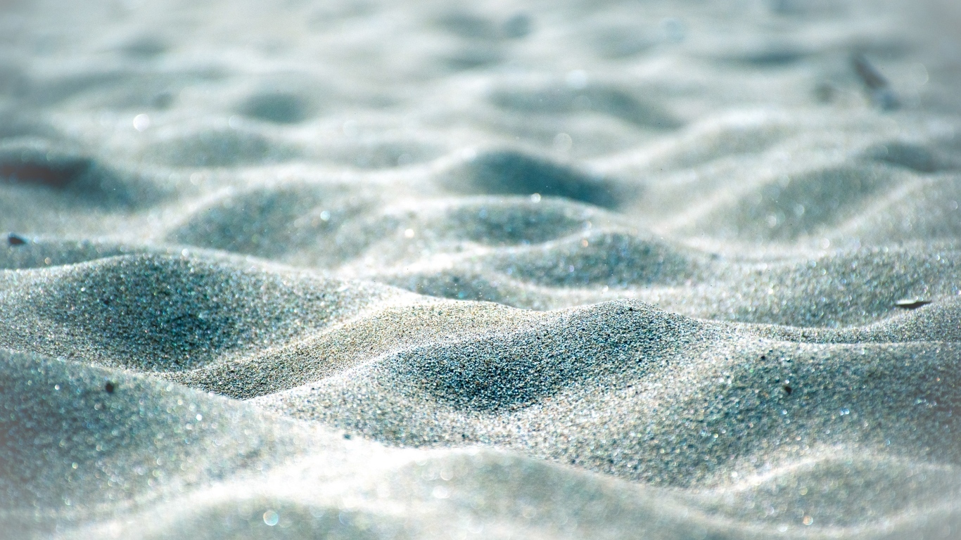 Блестящие волны песка на пляже