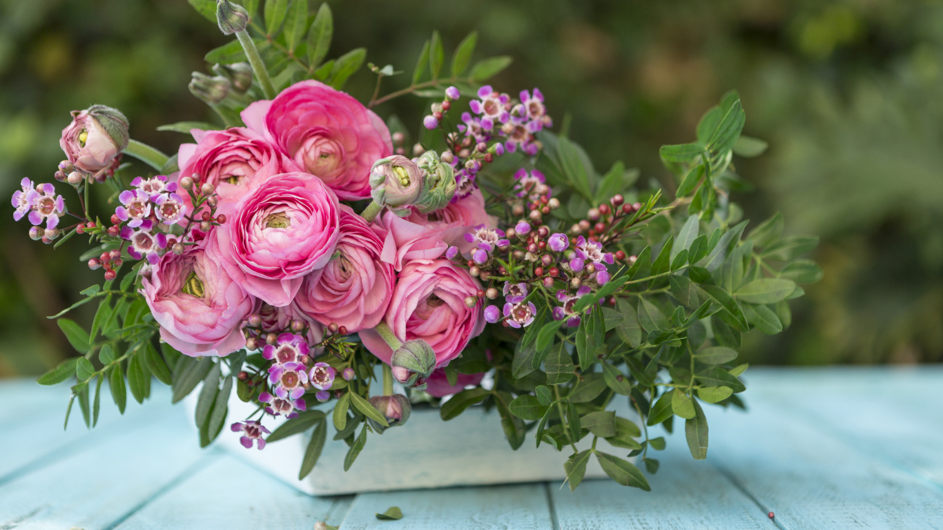 Букет розовых цветов лютика в ящике на голубом столе