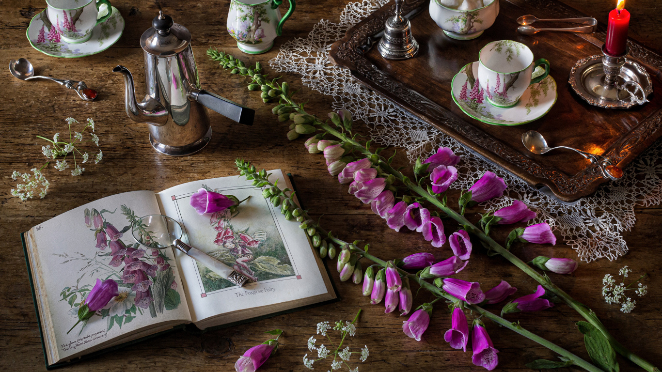 Розовые цветы на столе с книгой и чаем