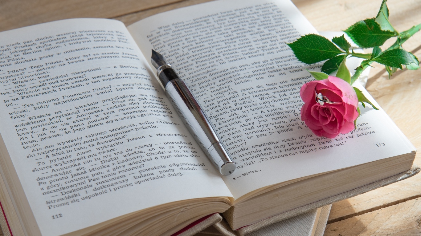 Розовая роза с кольцом на книге 