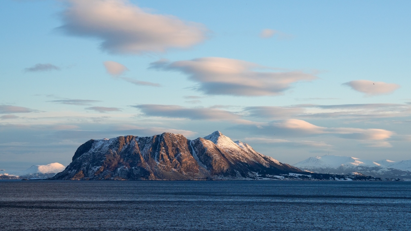 Скала в лучах солнца в море