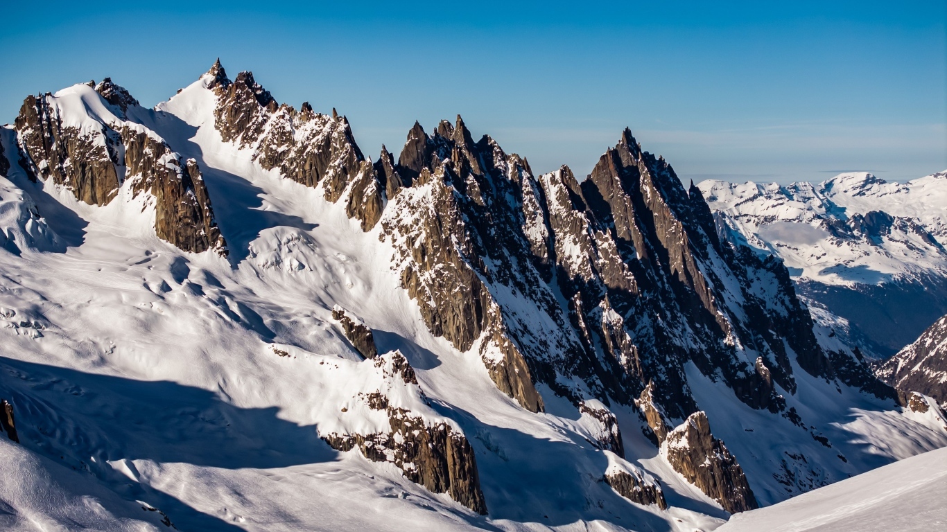 Солнце покрывает заснеженные горы