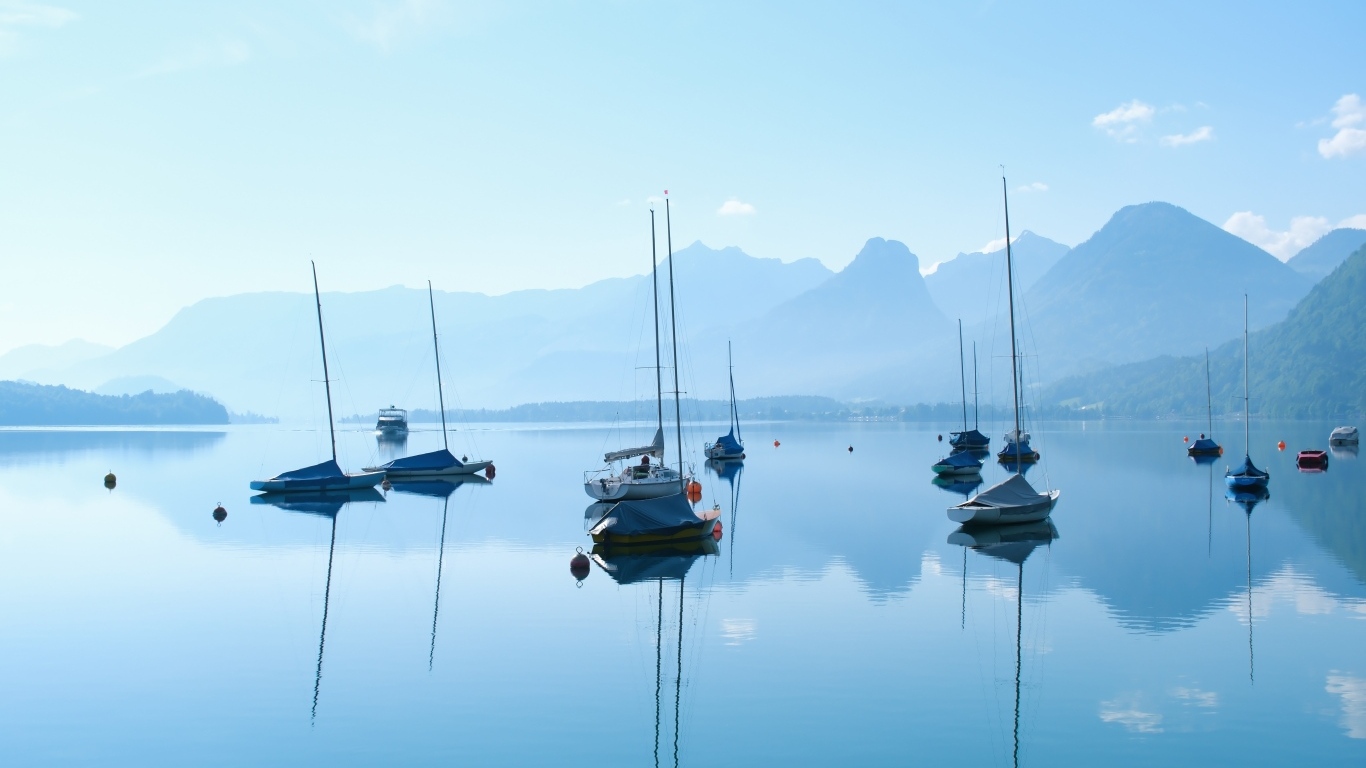 Лодки на озере у гор на рассвете в тумане