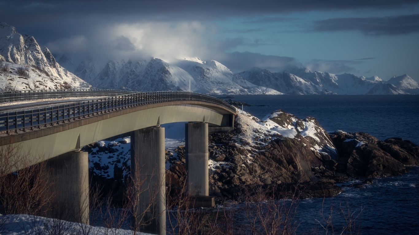 Мост через реку в заснеженных горах 