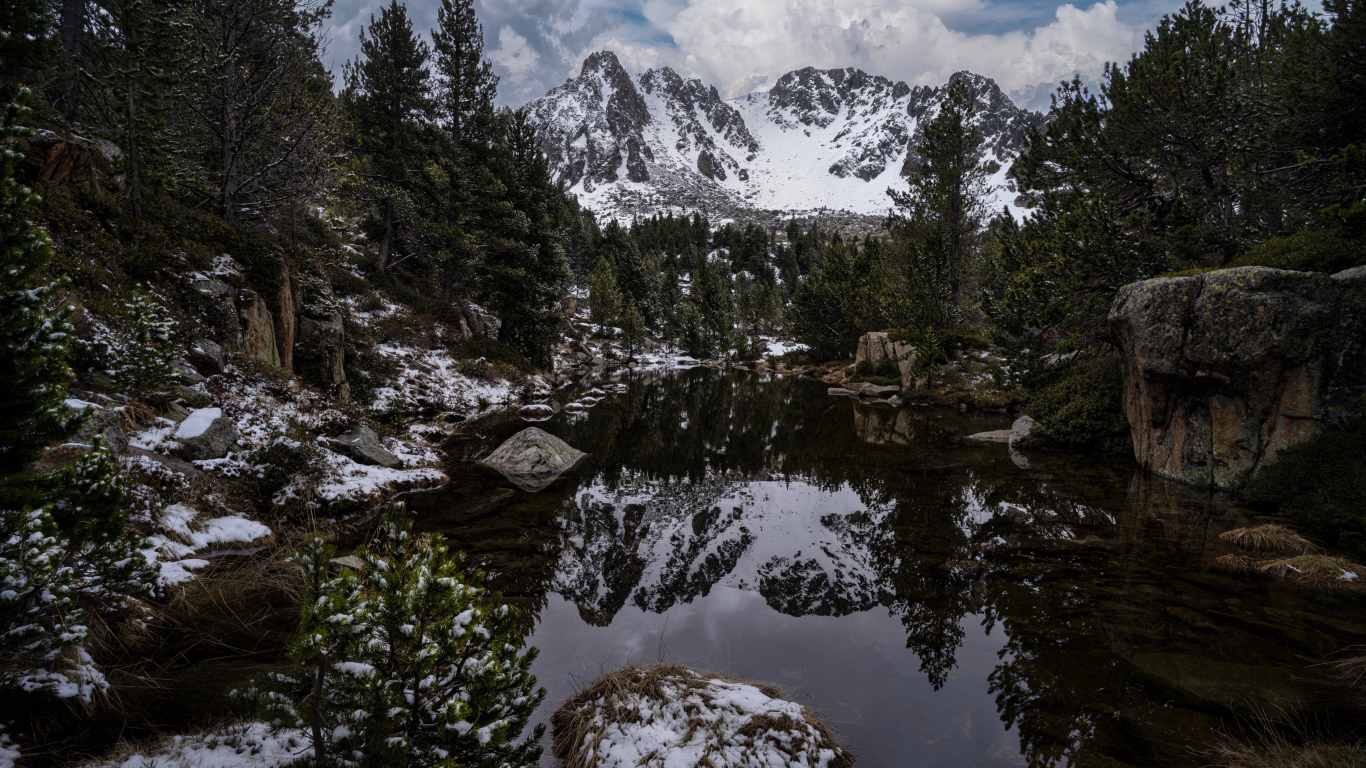 Холодная вода в озере с большими камнями на фоне гор