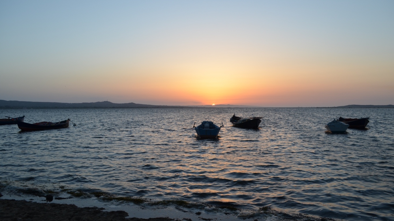 Лодки на морском побережье на закате