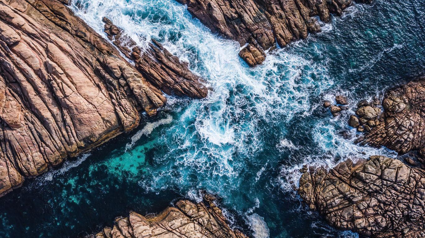 Вид на бушующее голубое море между камней 