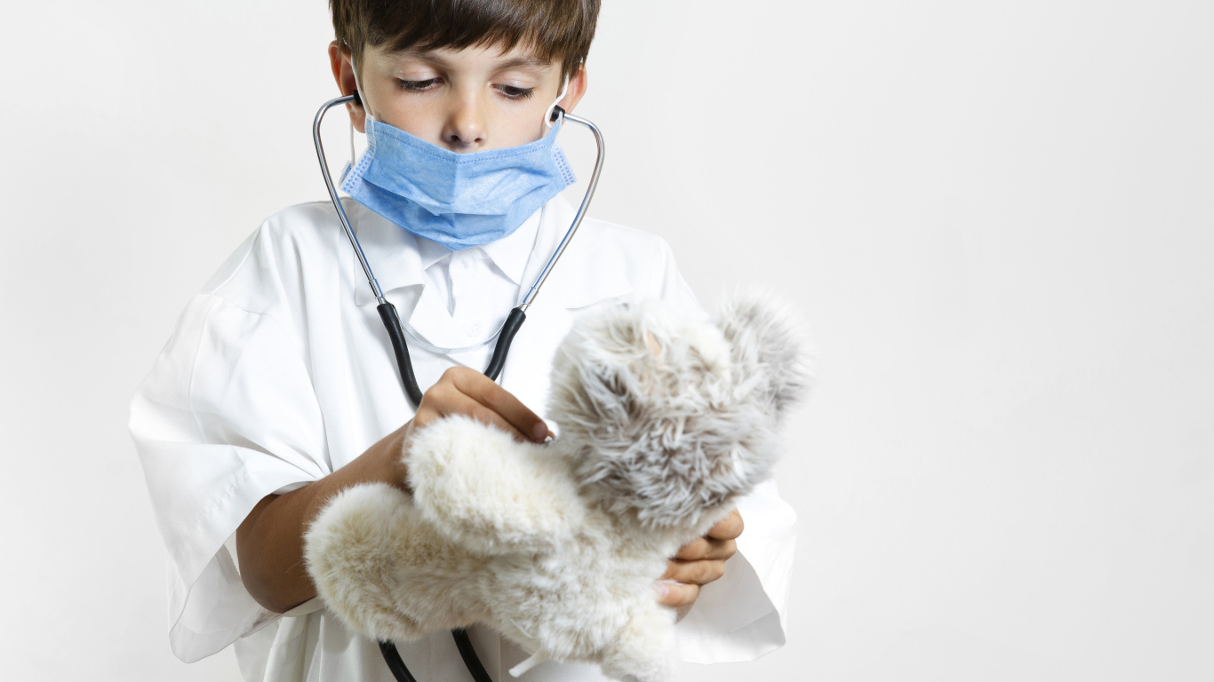Мальчик в костюме врача с игрушечным медведем