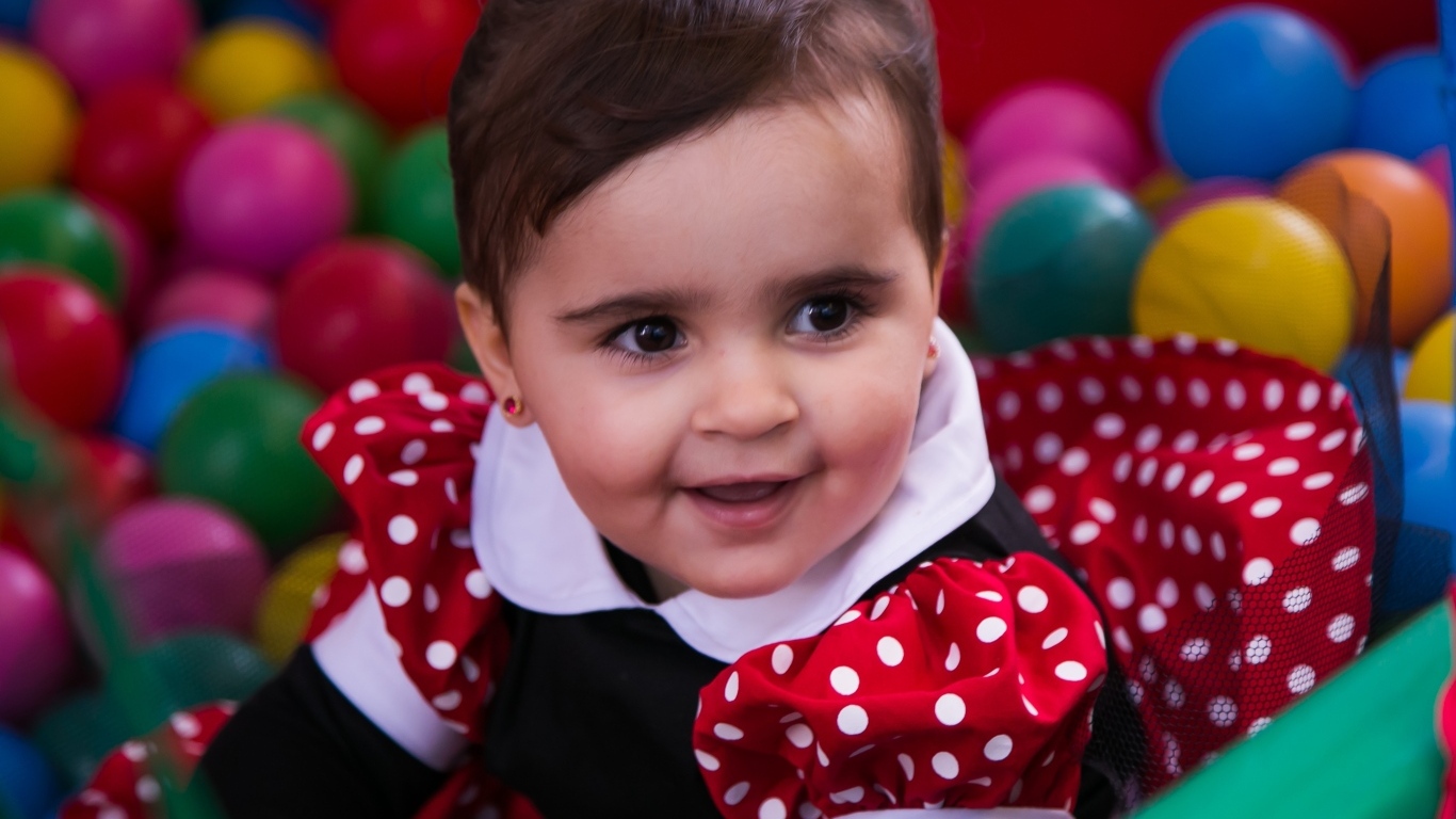 Кареглазая девочка в бассейне с шариками