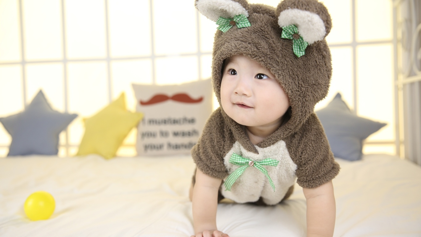 Ребенок в костюме медвежонка на кровати