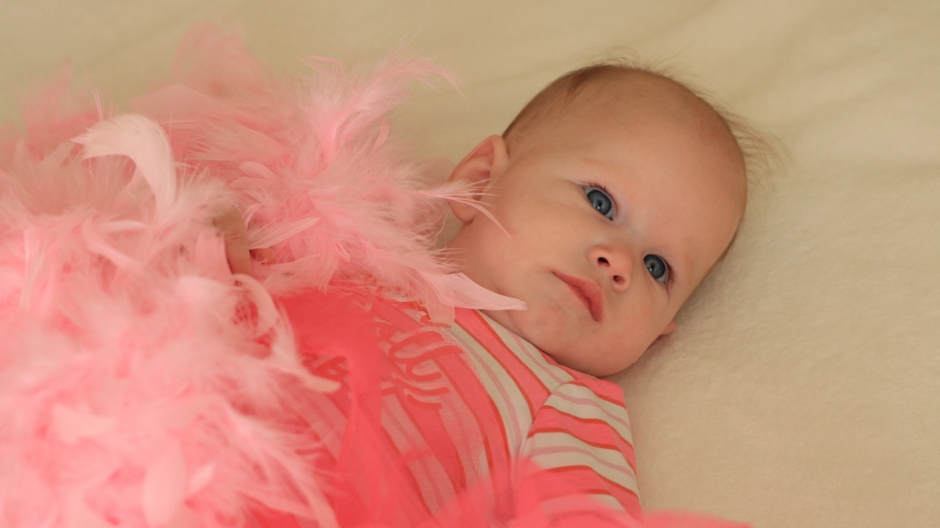 Милая малышка с розовыми перьями