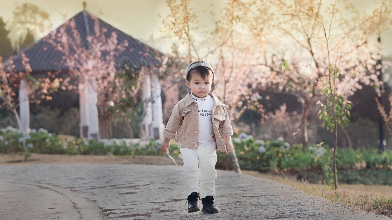 Милый мальчик гуляет по дороге у дома