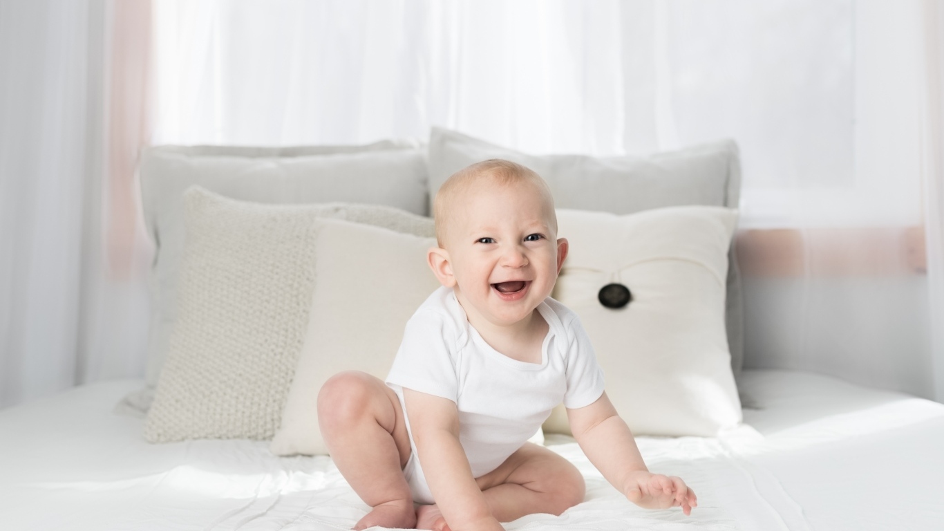 Смешной маленький ребенок на кровати