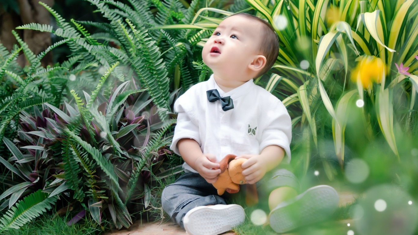 Маленький азиатский ребенок в зеленой траве