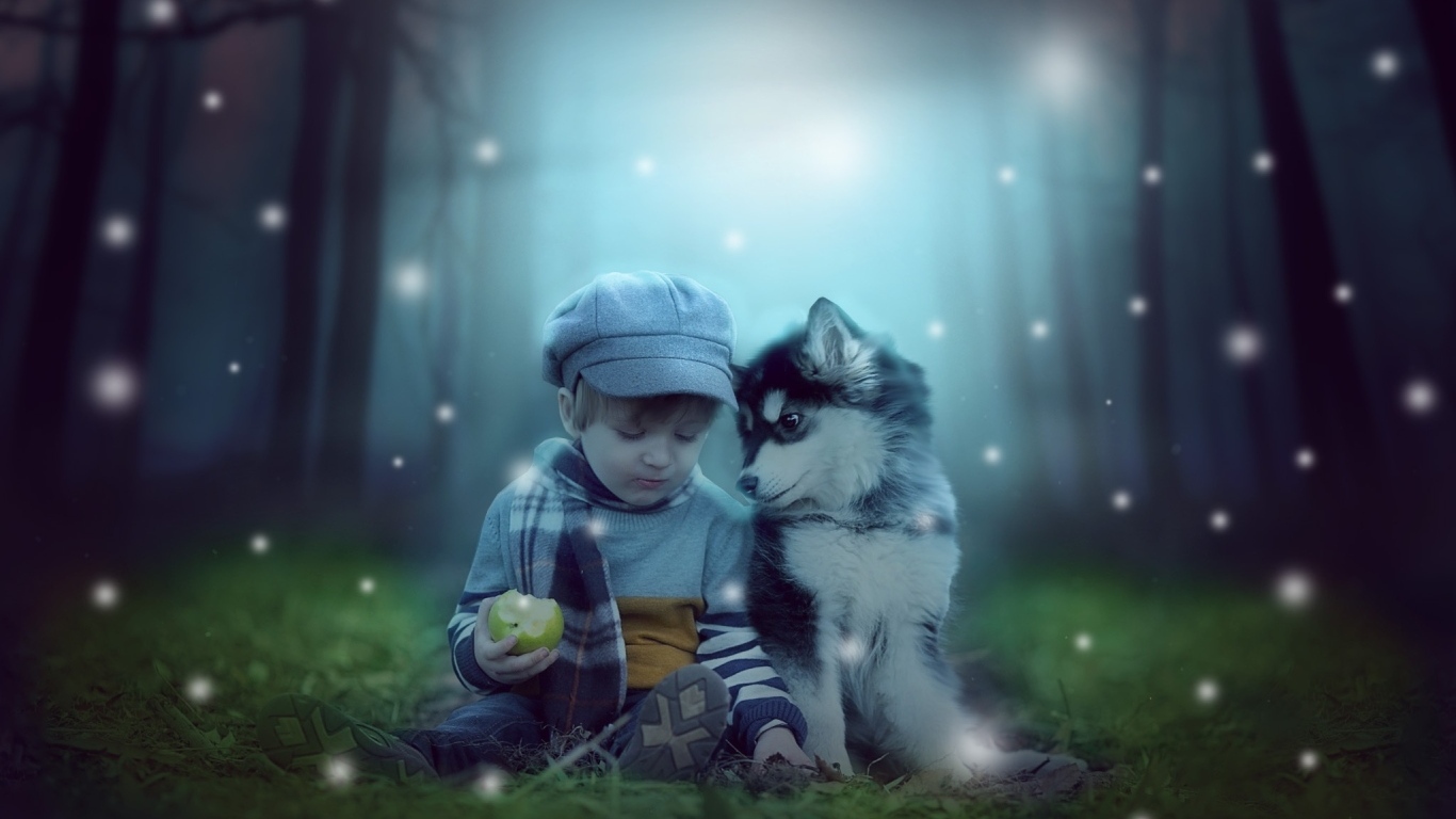 Маленький мальчик с щенком сидят на траве в лесу