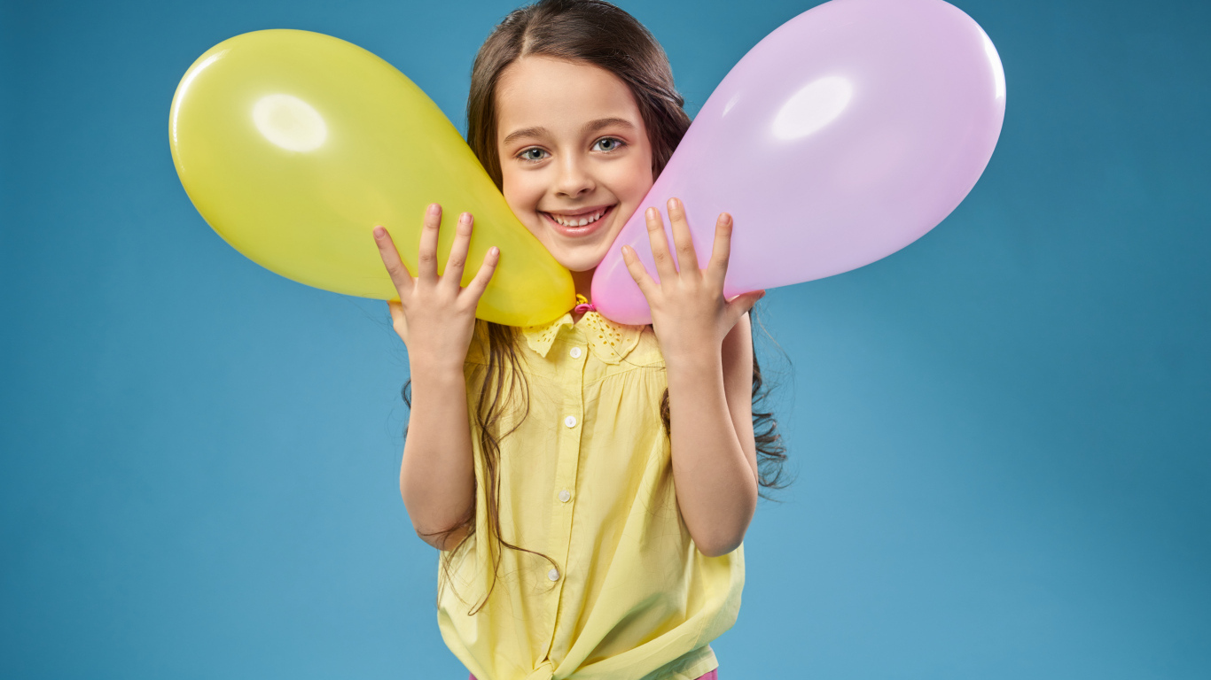 Маленькая девочка с воздушными шариками на голубом фоне