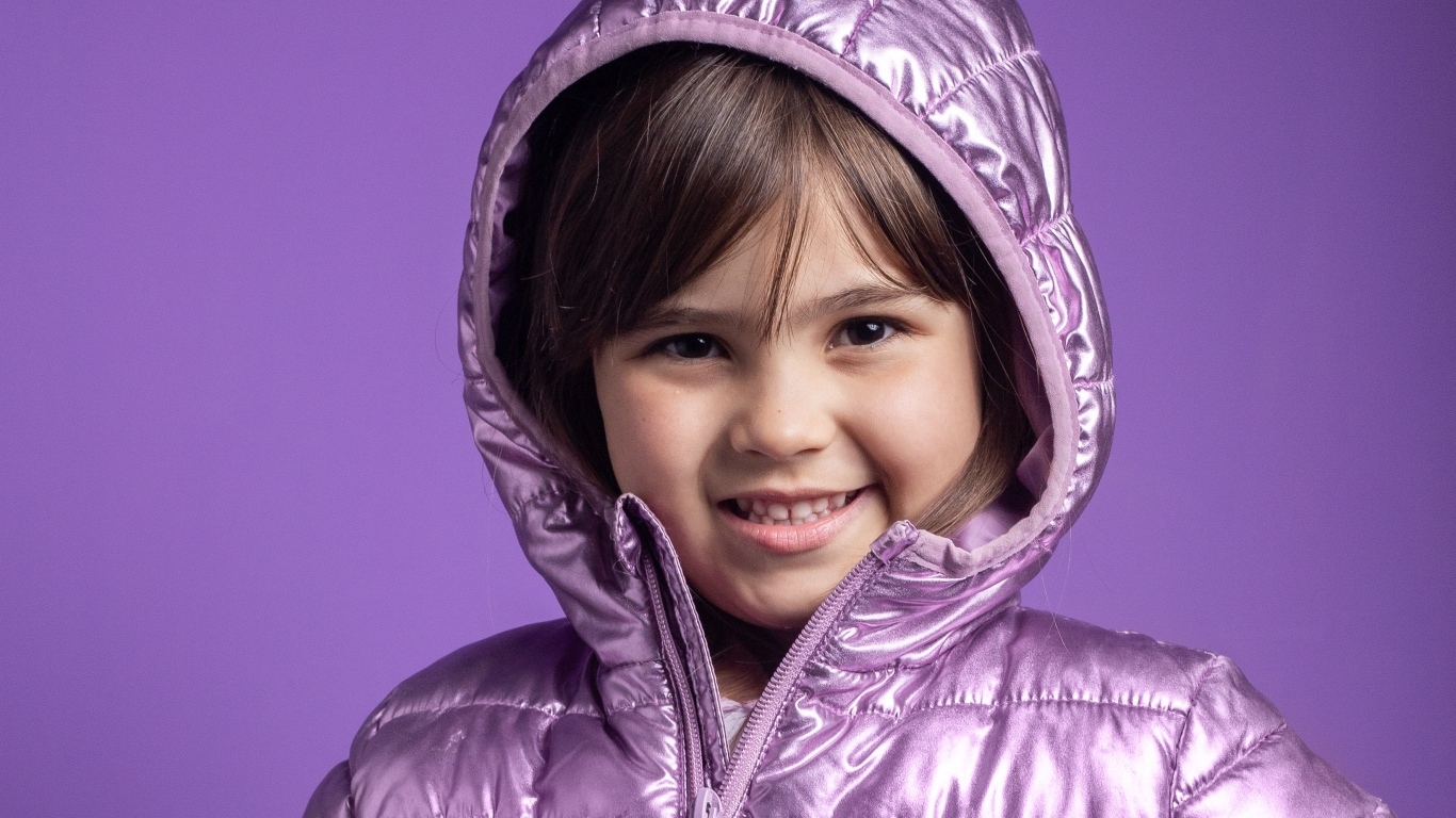 Улыбающаяся девочка в сиреневой куртке
