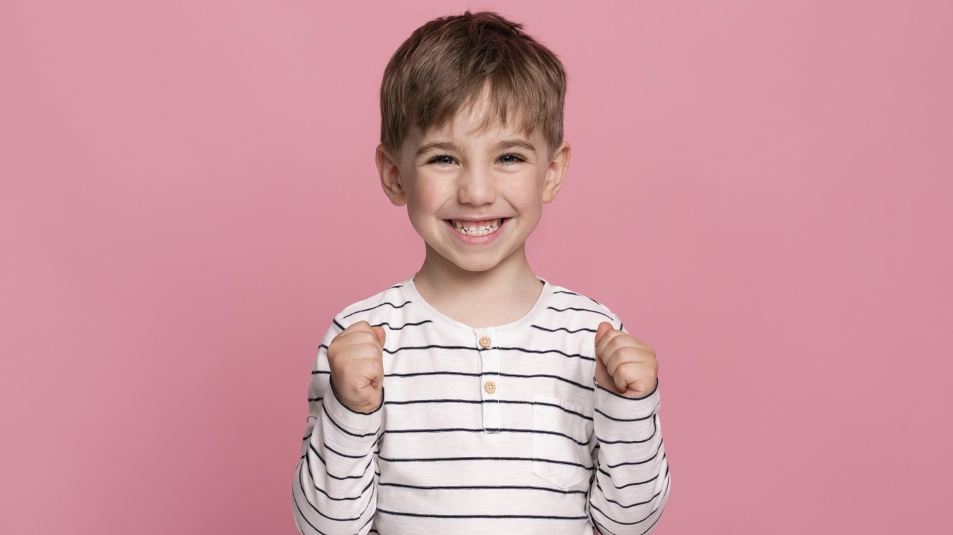 Улыбающийся маленький мальчик на сиреневом фоне