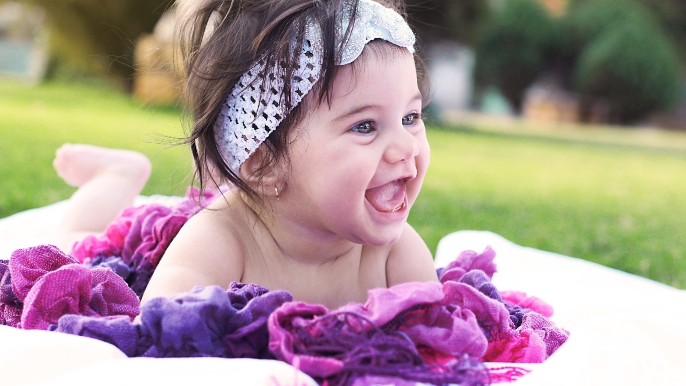 Улыбающаяся маленькая девочка с повязкой на голове 