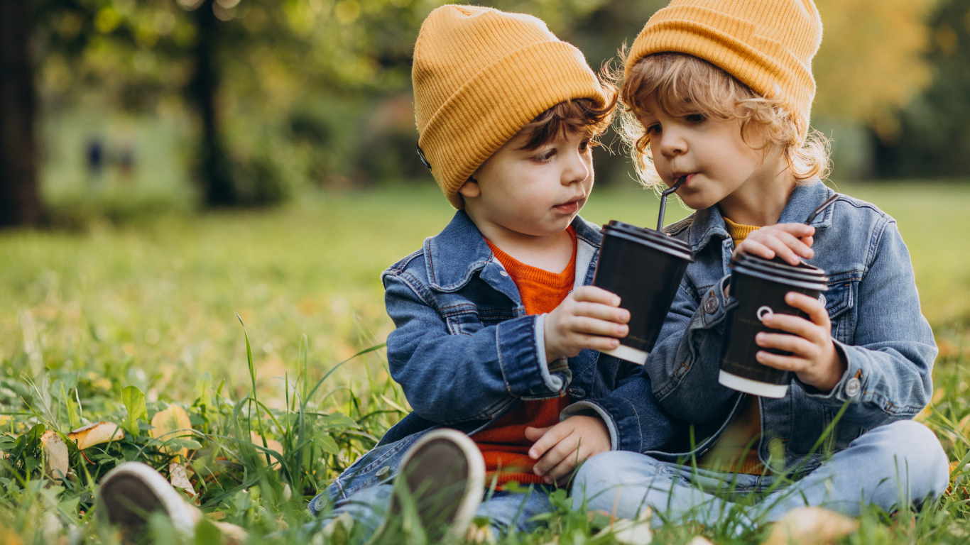 Два маленьких  брата сидят на траве