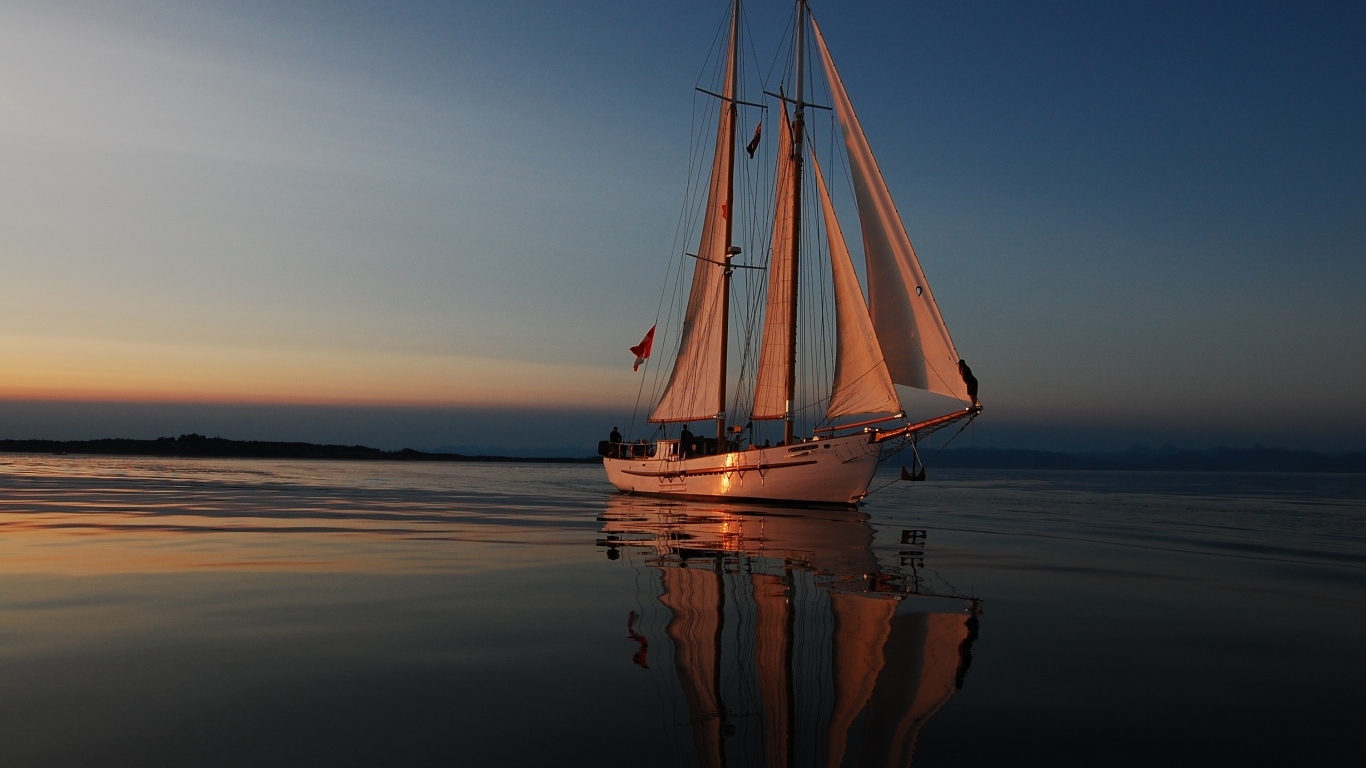 Большая парусная яхта в море на закате