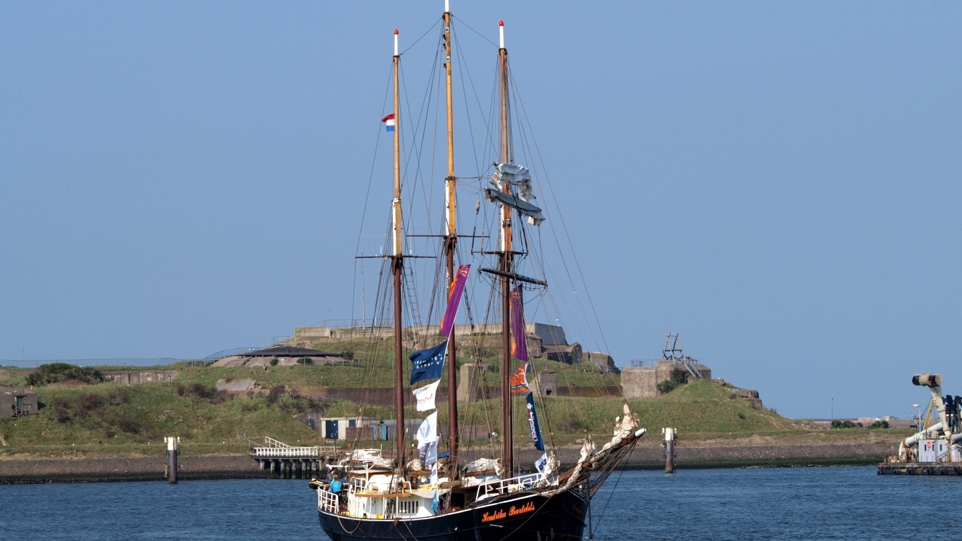 Большой корабль с опущенными парусами в гавани