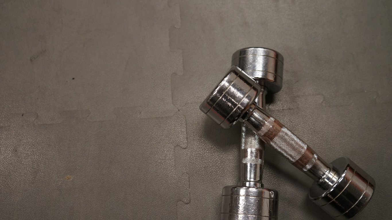 Две железные гантели на сером фоне