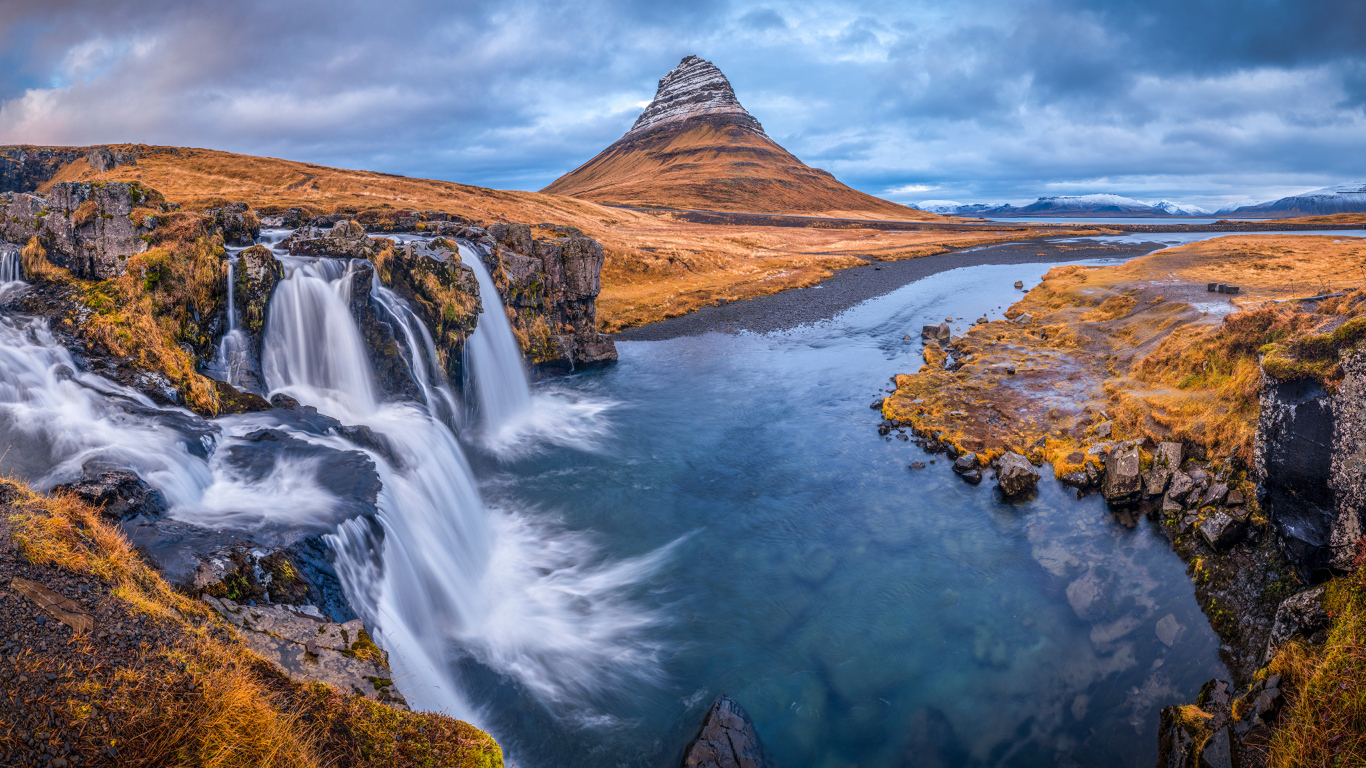 Вид на реку, водопад и гору Киркьюфетль под пасмурным небом Исладнии