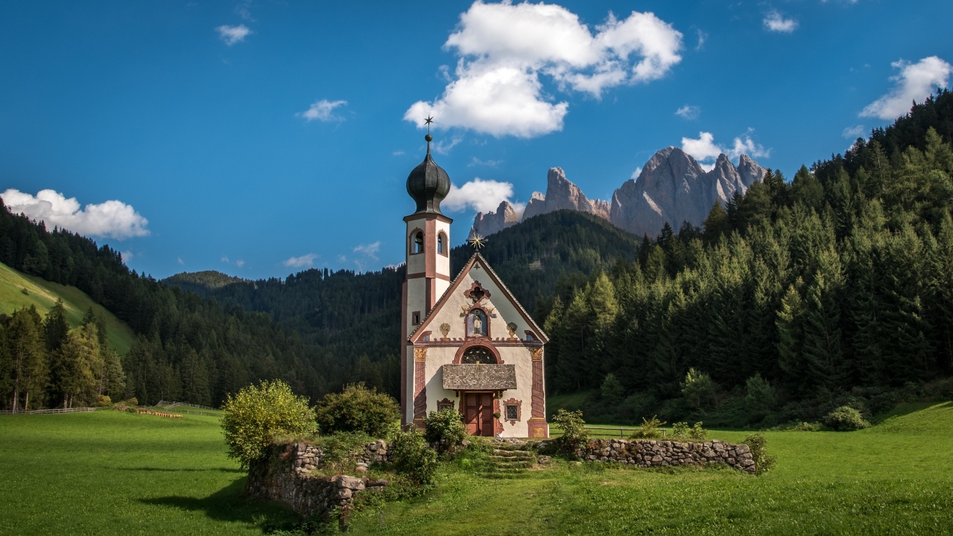 Старая церковь на фоне гор под красивым голубым небом, Италия