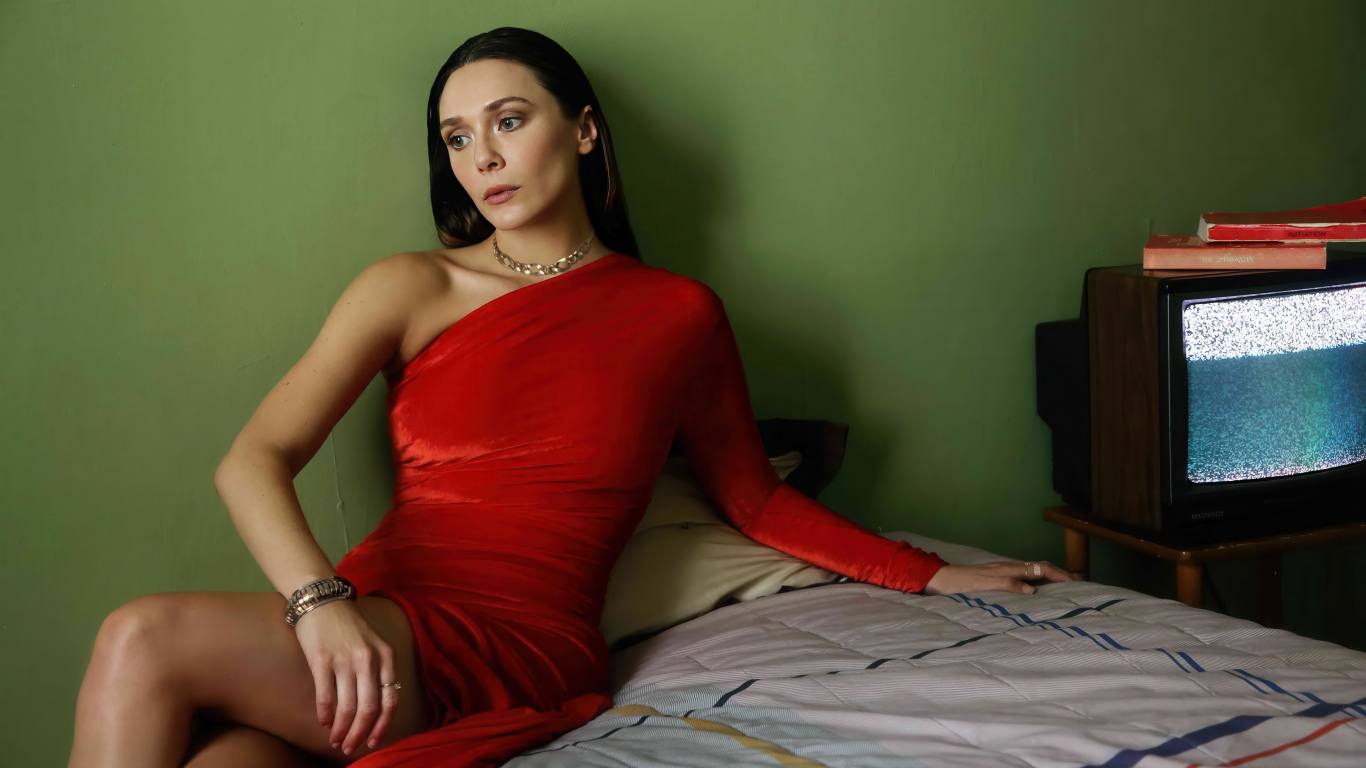 Актриса Элизабет Олсен в красном платье сидит на кровати