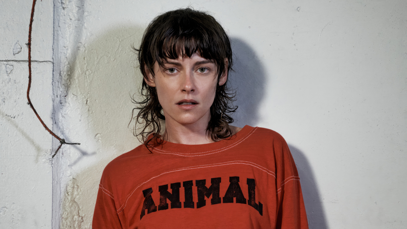 Актриса Кристен Стюарт стоит у серой стены