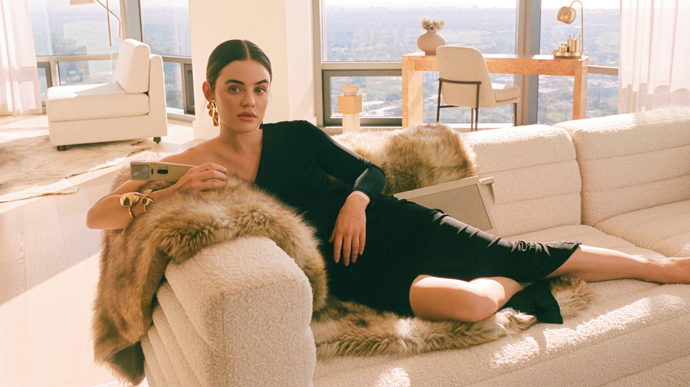 Актриса Люси Хейл в черном платье лежит на диване